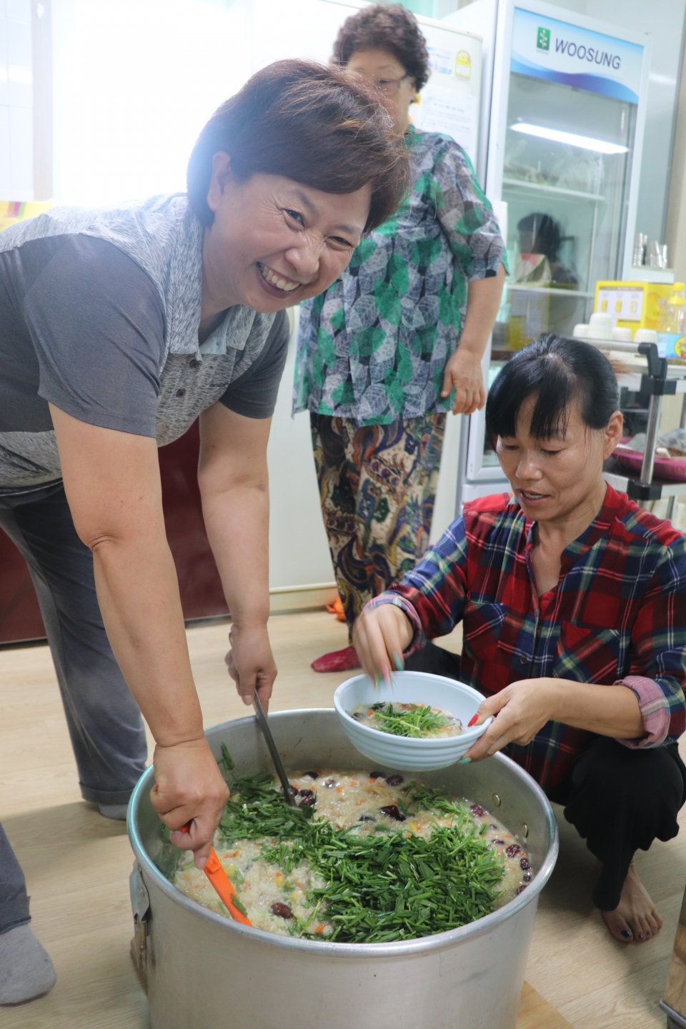 최경옥(55)씨와 이이숙(54)씨가 그릇에 닭죽을 옮겨 담고 있다. 초록색의 정구지(부추의 방언)가 입맛을 돋운다.