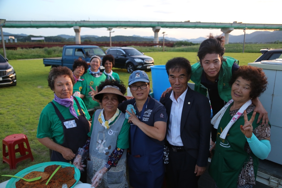 "우리가 만든 고추장떡 한 번 잡숴봐요~" 새마을회 회원들과 김외식 군의회의장이 기념사진을 찍고 있다.