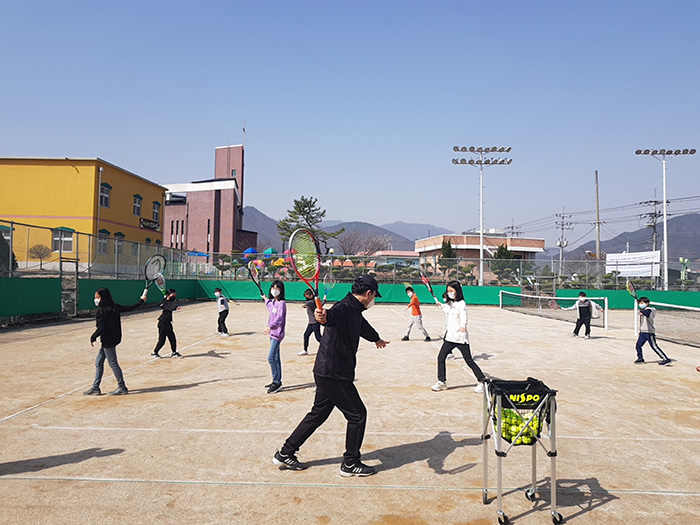 이원초등학교 학생들이 김전환 교장으로부터 테니스를 배우고 있다