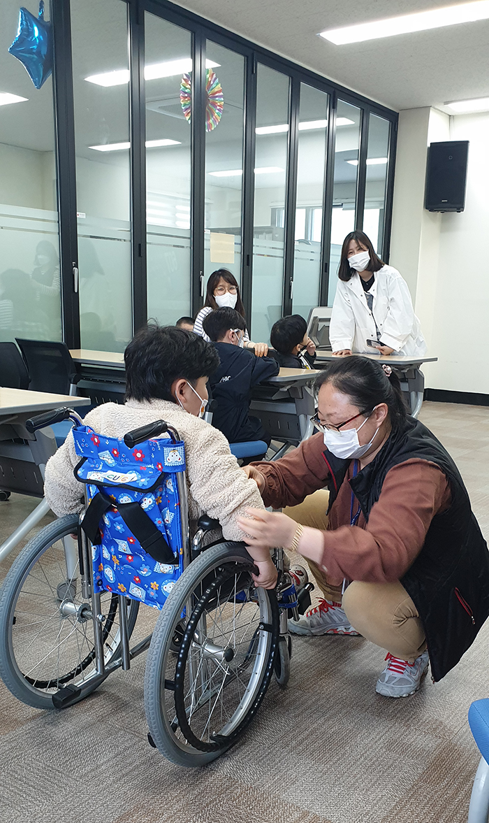 무궁화 어린이집 아동이 휠체어 체험을 하고 있다.