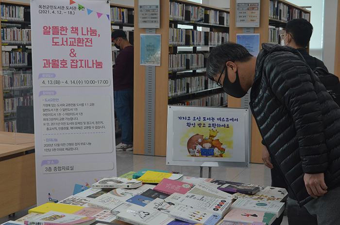 13일 오전 옥천군민도서관 종합자료실을 방문한 주민이 도서교환전 교환도서를 둘러보고 있다.