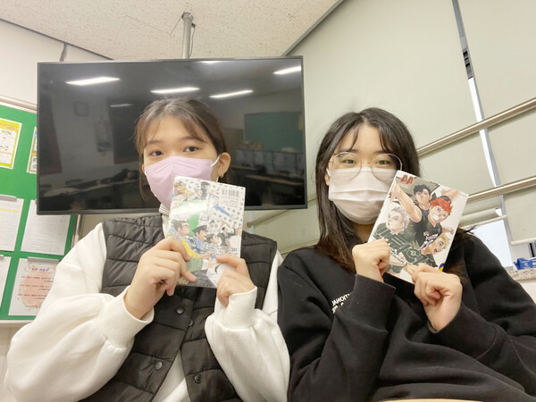 친구와 함께 좋아하는  만화책 '하이큐'를 들고 사진 찍은 박지우씨.(오른쪽)