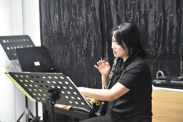 음악 동호회 '앙상블, 엘' 지휘를 맡은 김연주 씨가 색소폰, 플룻, 클라리넷, 피아노를 연주하는 단원들의 음정과 박자, 리듬을 점검하고 있다.