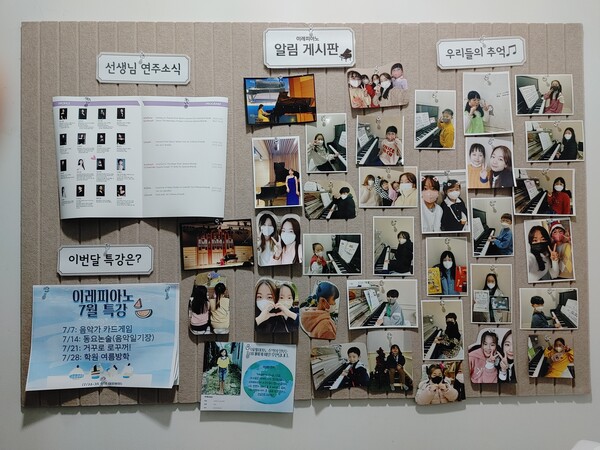 이레피아노 입구 앞에 있는 알림게시판. 선생님 연주 소식, 이달 특강과 함께 김아현 원장과 학생들이 함께 찍은 사진들이 걸려 있다.