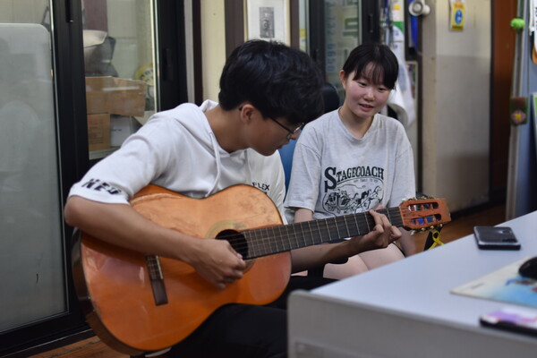 김재환 학생이 쉬는 시간을 활용해 기타를 연주하고 있다.