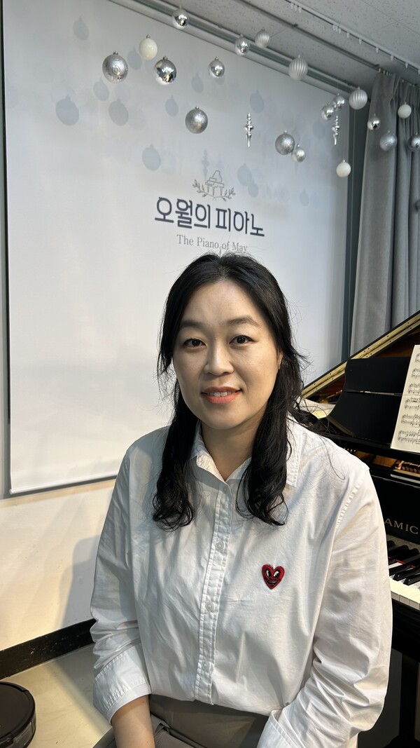 한혜경 대표가 피아노 앞에 앉아 웃고 있다. 8살 때부터 피아노를 배웠고, 살면서 한순간도 피아노를 손에 놓았던 적이 없다.