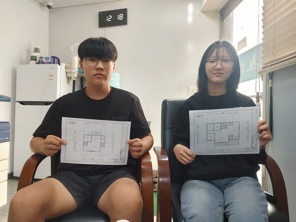 옥천고 1학년 김민아, 곽솔찬 학생이 '내가 살고 싶은 주택 도면'을 직접 그린 뒤 출력한 평면도를 들고 기념촬영을 하고 있다.