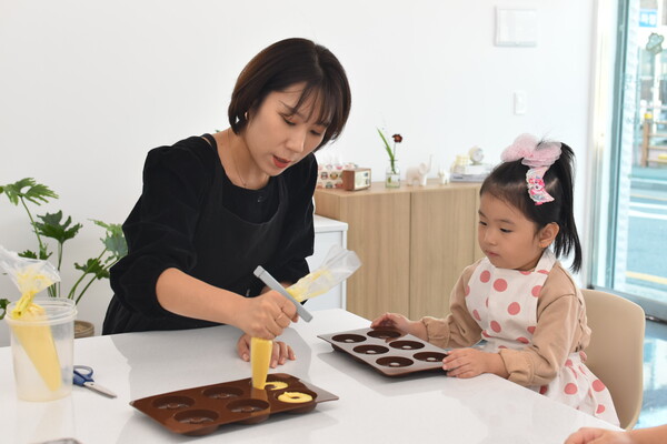 디저트공방 '담다' 진수현 대표가 지난달 22일 오전에 찾아온 어린이들과 함께 도넛을 만들고 있다. 