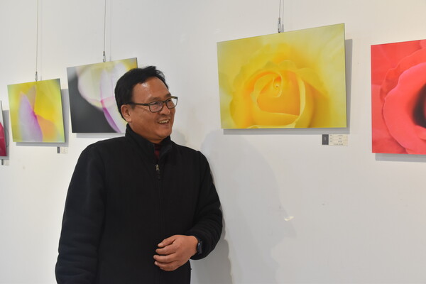 윤진섭 씨가 영동 노근리평화공원에서 촬영한 '노란 장미', '빨간 장미'를 바라보며 미소를 띠고 있다.