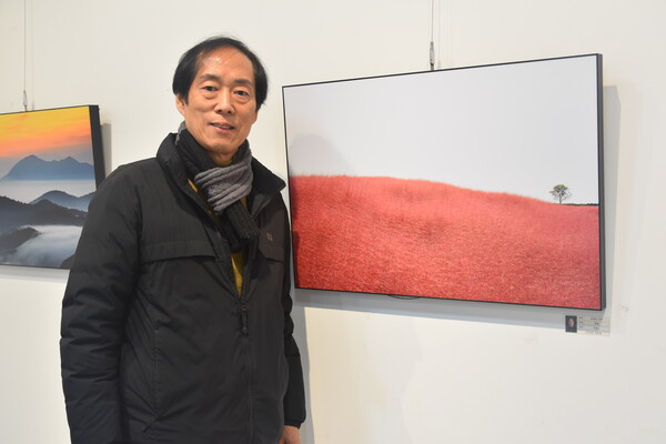 박병노 씨가 안성 팜랜드 내 핑크뮬리 군락을 찍은 '분홍빛 언덕' 앞에서 기념촬영을 하고 있다.
