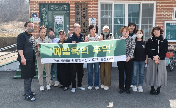 점심나눔 봉사 참여자 및 관계자들이 용목리회관 앞에 모여 기념촬영을 하고 있다.